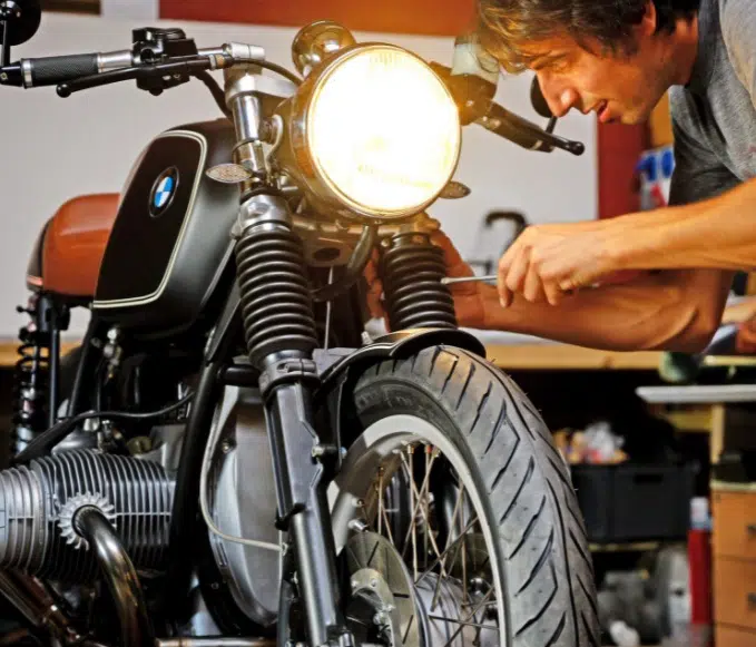 Un homme bricole une moto