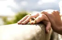 person holding gold wedding band