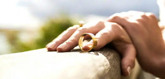 person holding gold wedding band